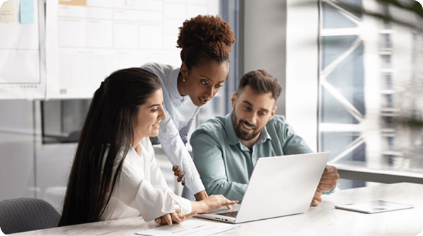Diverse team collaborating around a laptop in a modern office.